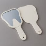 آینه دستی طرح دندان نشکن با رنگ‌بندی جذاب برای بررسی دندان‌ها توسط بیماران در کلینیک یا منزل.